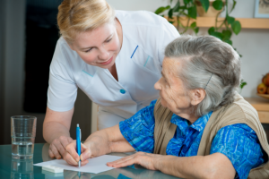 caregiver assisting her patient in writing